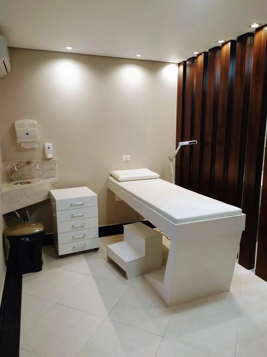 Sala de atendimento com maca, pia e armário